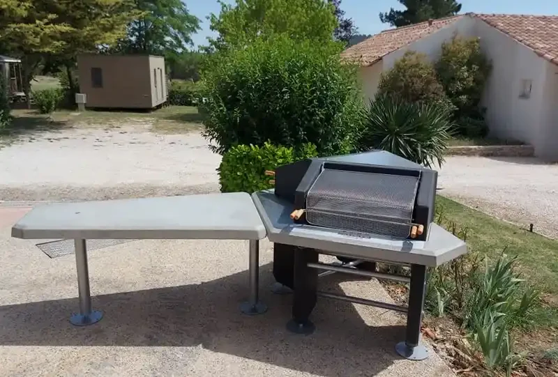 Barbecue collectif avec table installé dans un jardin