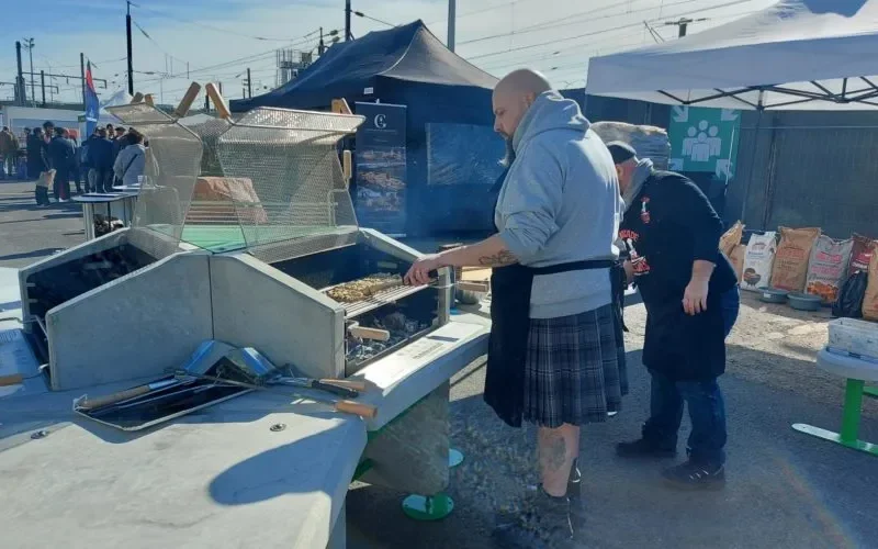 Équipe préparant de la nourriture sur un barbecue collectif