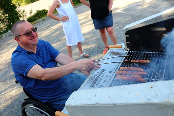 Utilisation du barbecue PMR Utilisateur en fauteuil roulant devant un barbecue collectif PMR
