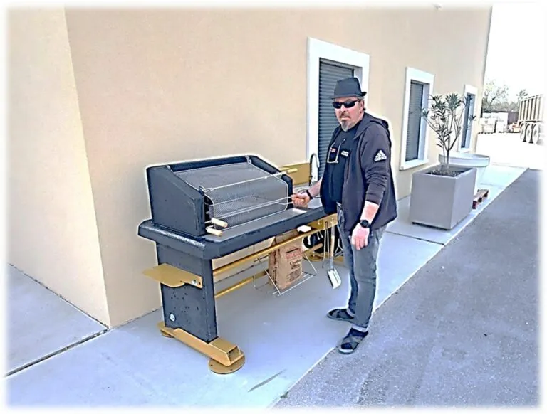 Technicien devant le barbecue Technicien devant un barbecue collectif La Vie Dehors installé en intérieur