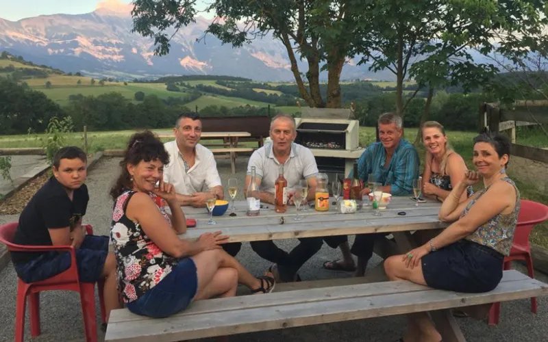 Repas convivial au gîte Groupe partageant un repas autour d’un barbecue collectif dans un gîte