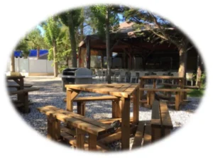 Barbecue collectif avec tables en bois dans un camping