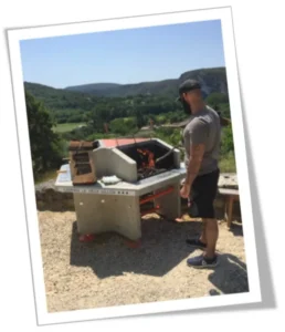 Vacancier utilisant un barbecue collectif dans un camping